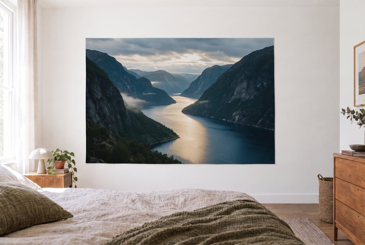 Fjord in evening light tapestry in a bright bedroom opposite the bed, wooden dresser at right – blue and grey