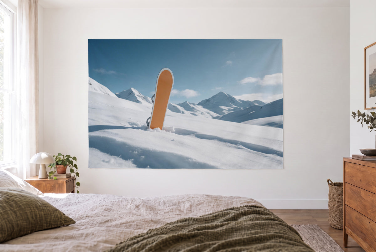 Snowboard in deep snow tapestry in the bright bedroom opposite the bed, wood dresser on the right – white and blue