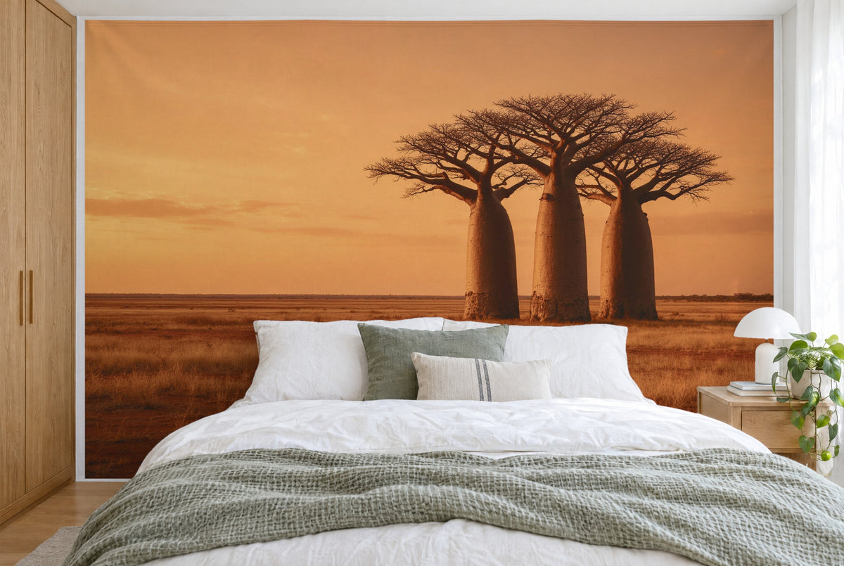 XXL printed fabric: three baobab trees at right, wide steppe at left under a sunset sky, filling the wall behind the bed