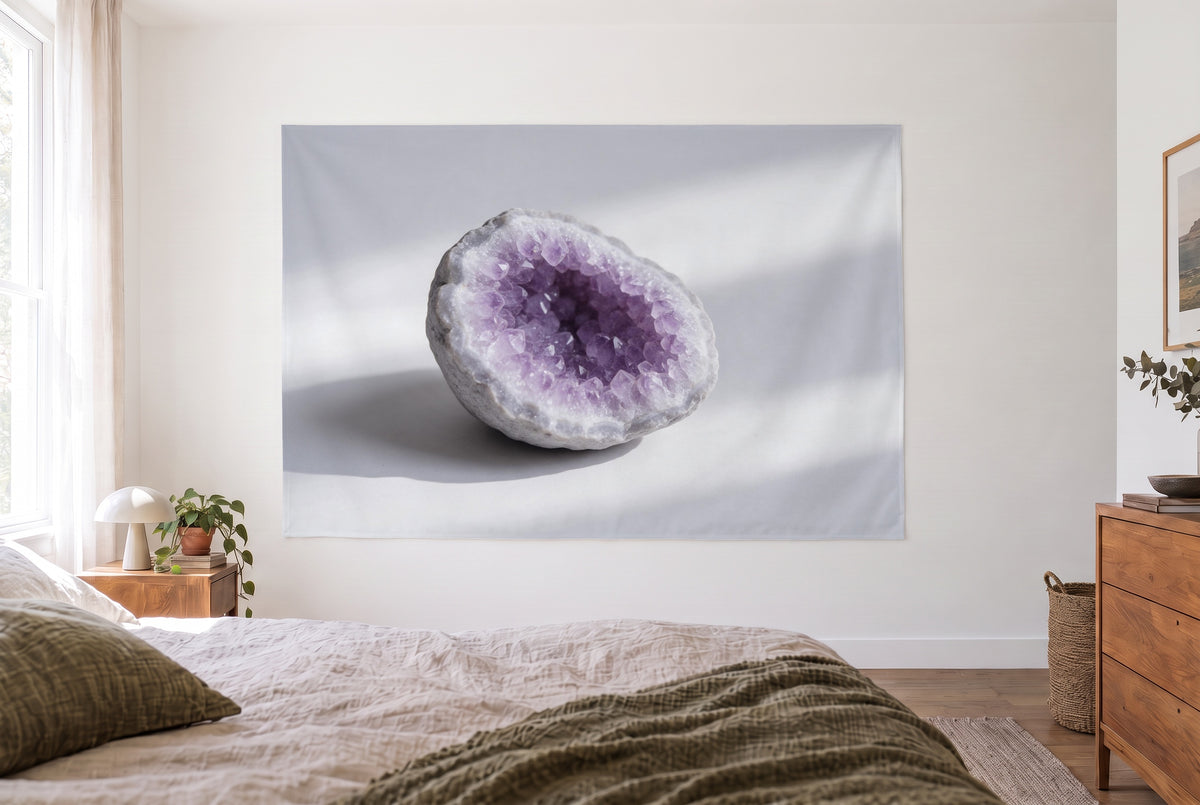 Wandtuch Amethyst-Druse in Nahaufnahme im hellen Schlafzimmer gegenüber dem Bett, rechts eine Holzkommode – Violett