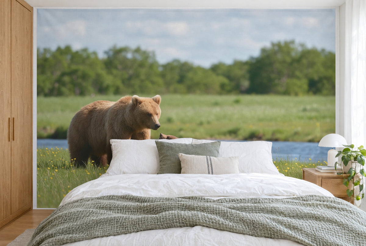Bedruckter Stoff im XXL-Format: Bärenmutter links auf Blumenwiese am blauen Fluss, wandfüllend hinter dem Bett