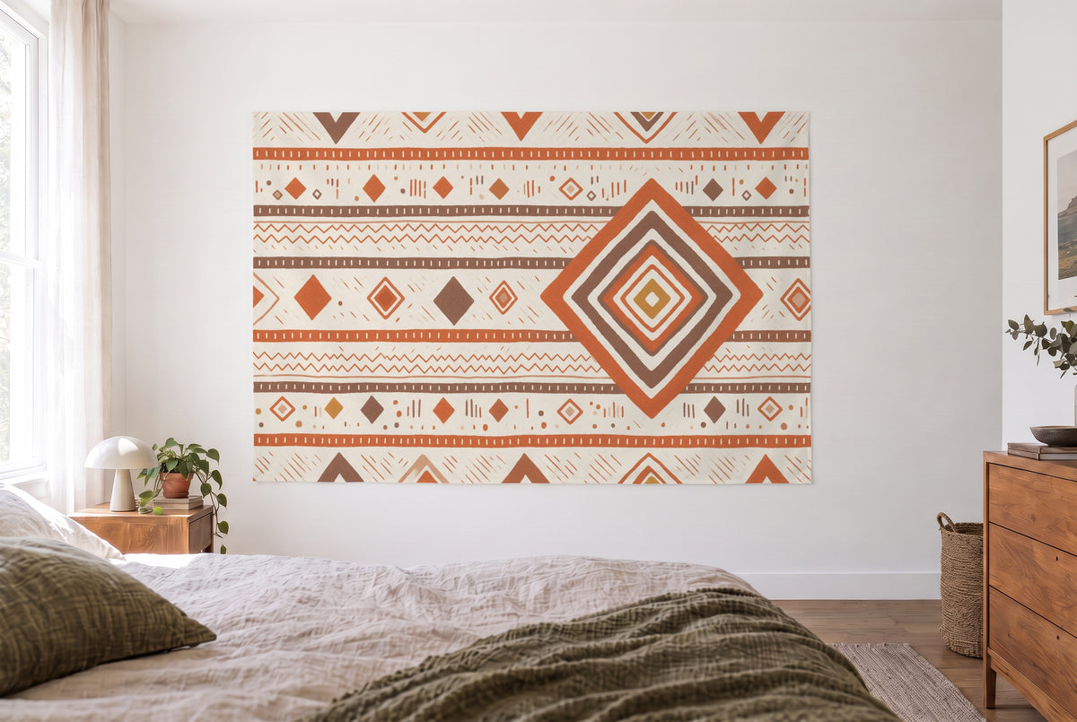 Berber pattern in earth tones tapestry in the bright bedroom opposite the bed, wooden dresser at right – orange and brown