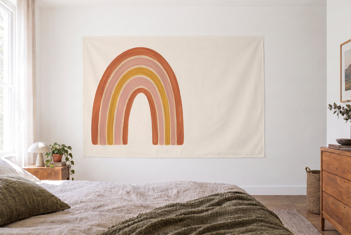 Wandtuch Boho-Regenbogen in Erdtönen im hellen Schlafzimmer gegenüber dem Bett, rechts eine Holzkommode – Orange und Rosa