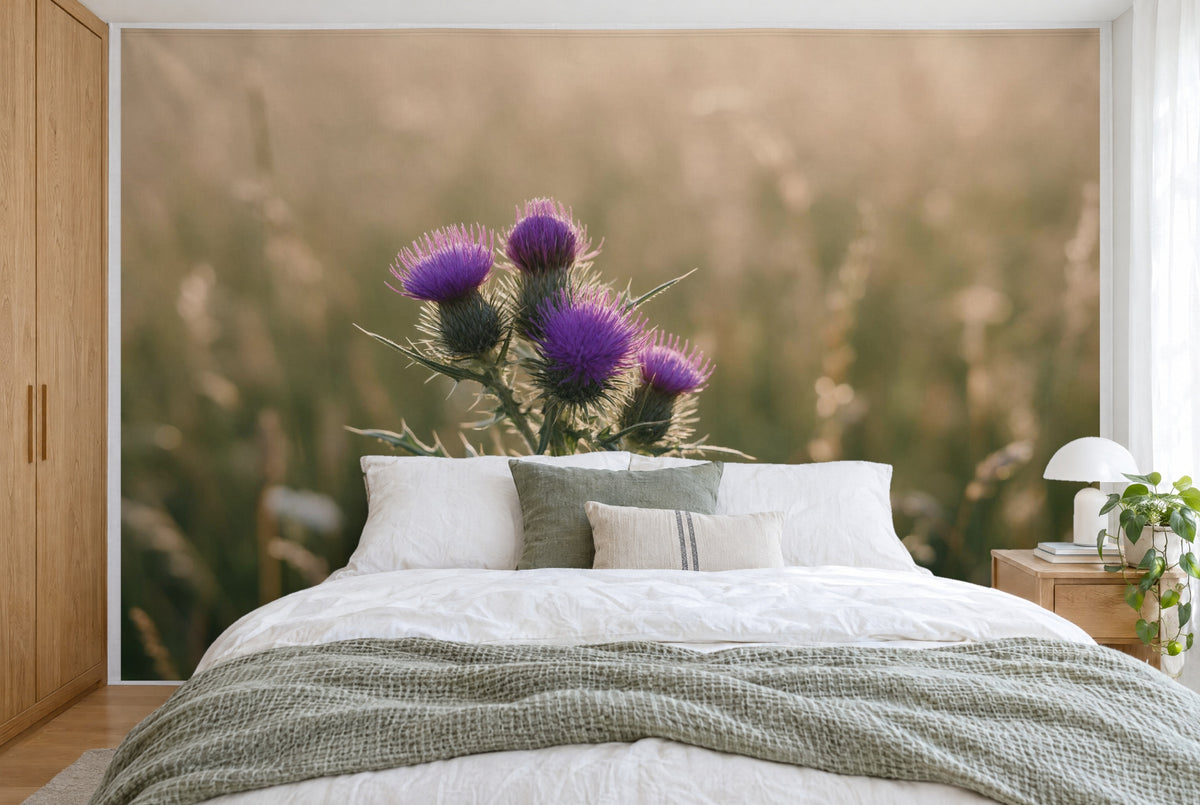 Bedruckter Stoff im XXL-Format: vier violette Distelblüten links der Mitte vor weicher Wiese, wandfüllend hinter dem Bett