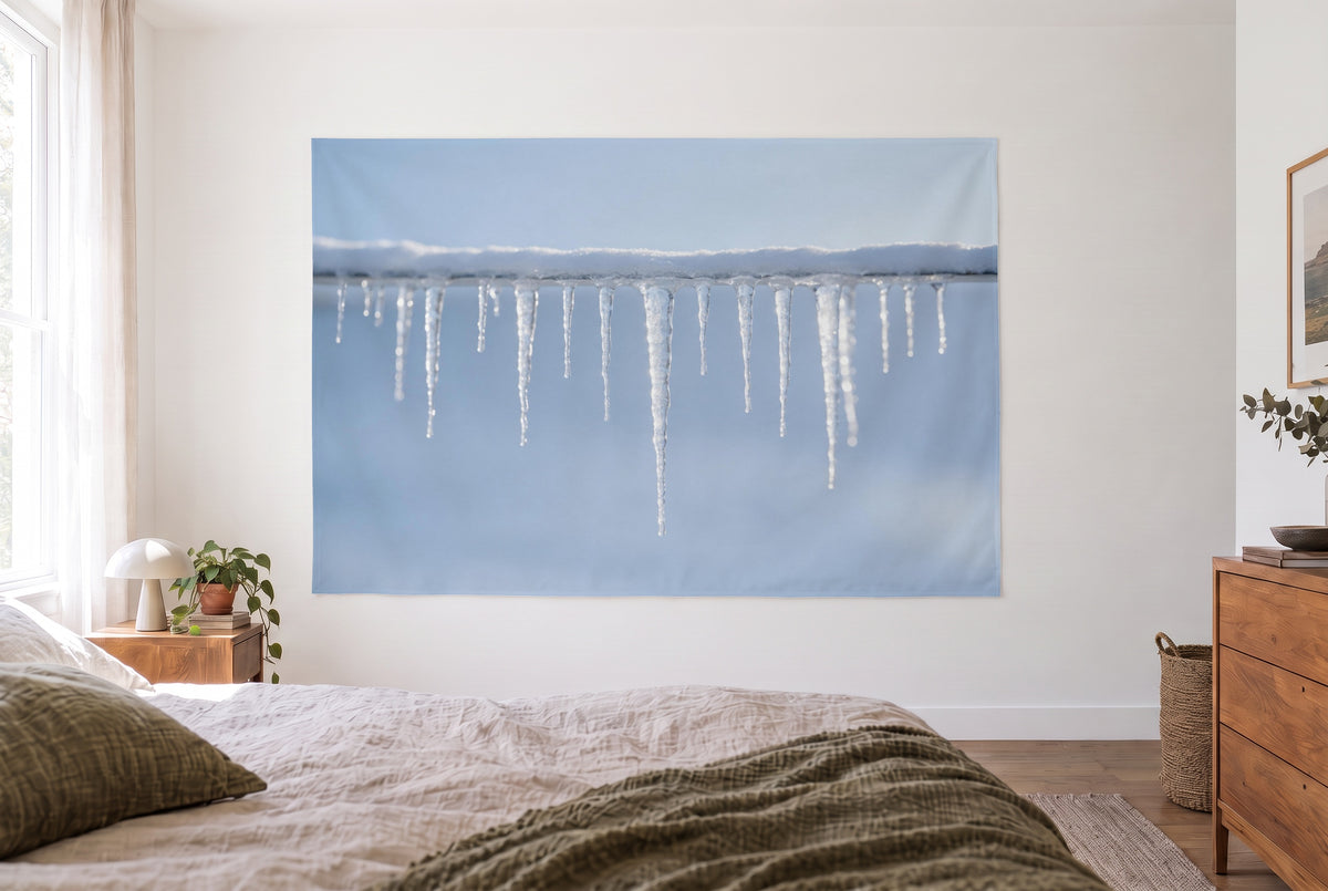 Icicles in winter tapestry in a bright bedroom opposite the bed, wooden dresser on the right – ice blue and white