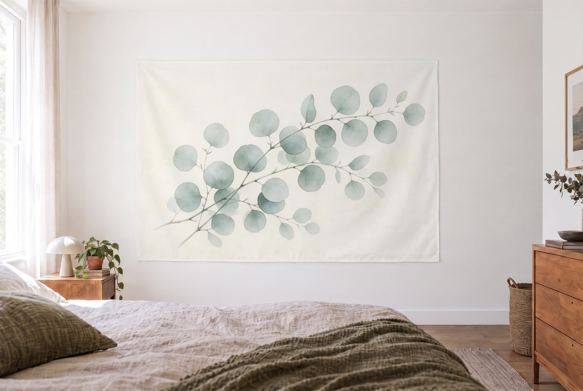 Eucalyptus branches watercolor tapestry in the bright bedroom opposite the bed, wooden dresser at right – green and beige