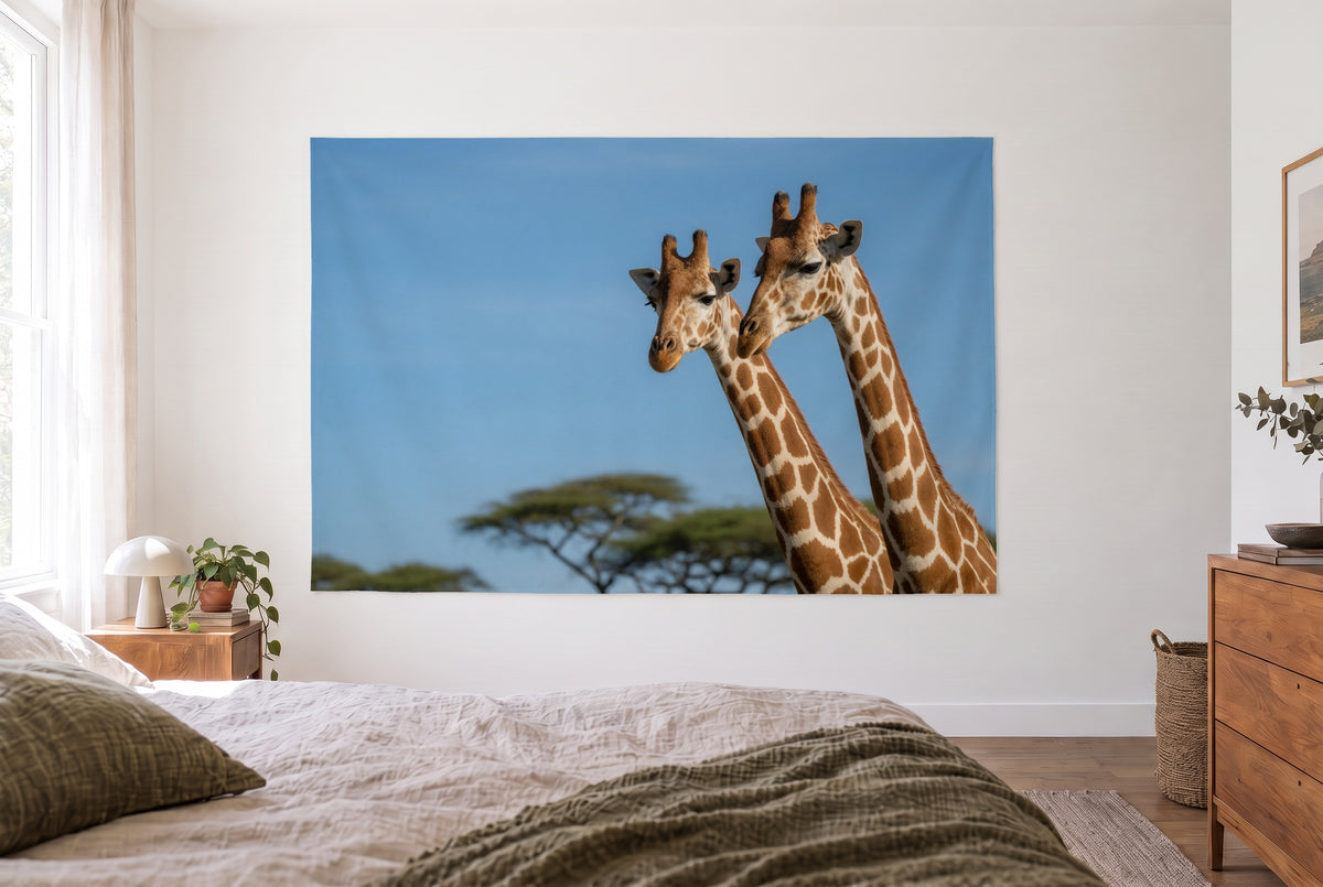 Giraffe Portrait tapestry in the bright bedroom opposite the bed, wooden dresser at right – brown and blue