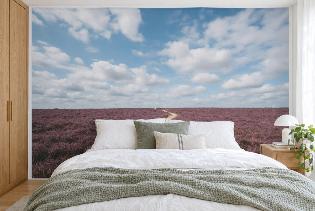 Bedruckter Stoff im XXL-Format: violette Heide und Cumuluswolken, sandbeige Pfade, wandfüllend hinter dem Bett
