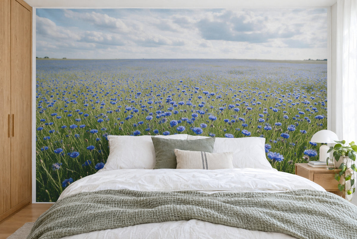 Bedruckter Stoff im XXL-Format: weites Kornblumenfeld bis zum Horizont, Wolkenhimmel, wandfüllend hinter dem Bett