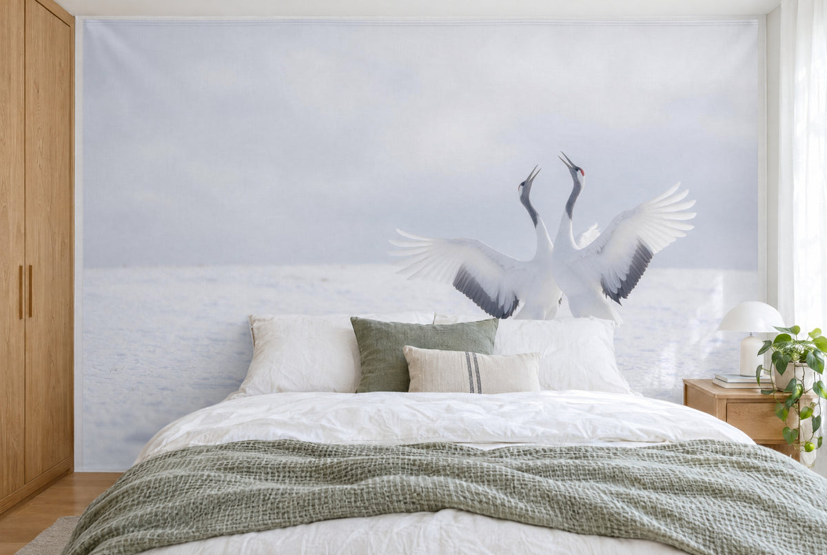 Bedruckter Stoff im XXL-Format: zwei Kraniche mit weiten Flügeln rechts, grauer Winterhimmel, wandfüllend hinter dem Bett