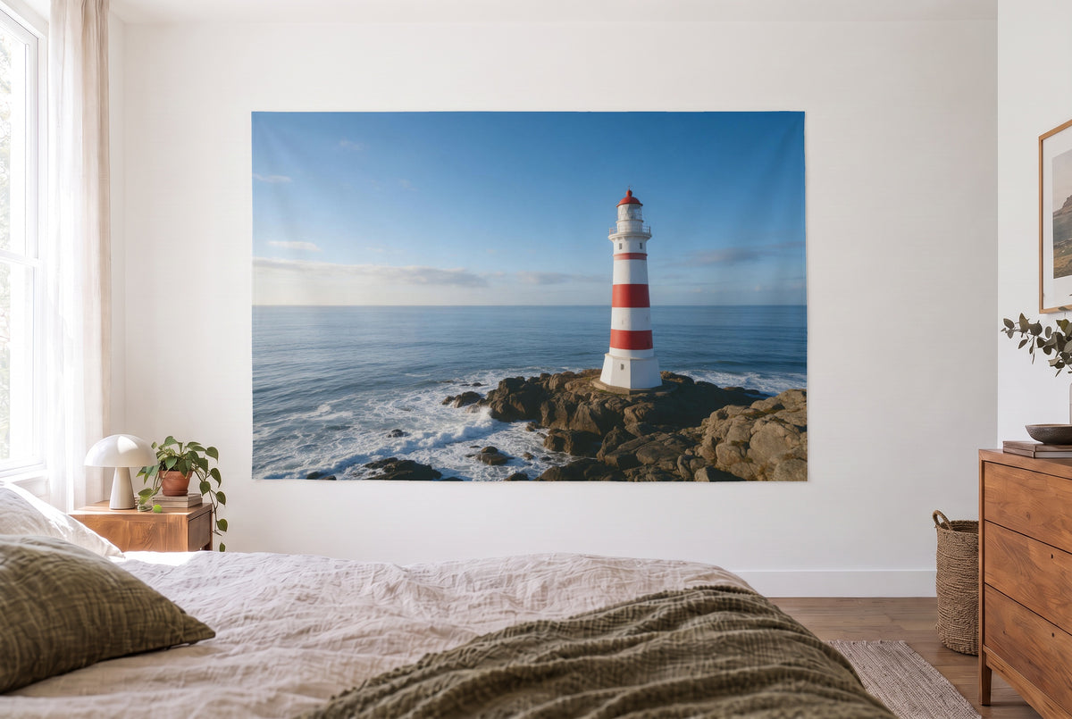 Lighthouse on the rocky coast tapestry in the bright bedroom opposite the bed, wooden dresser at right – blue, red and white
