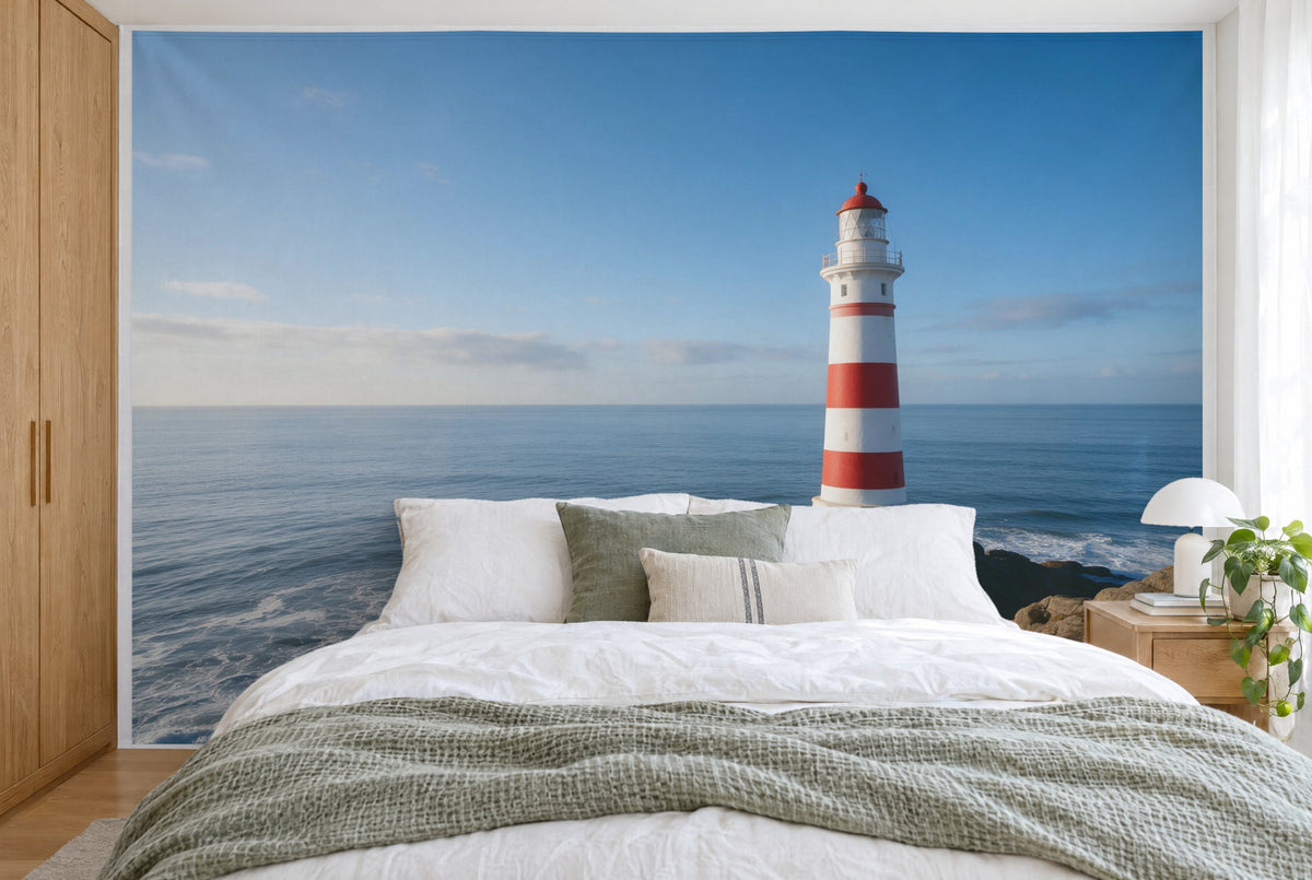XXL printed fabric: white-and-red lighthouse on the right before open sea and blue sky, filling the wall behind the bed
