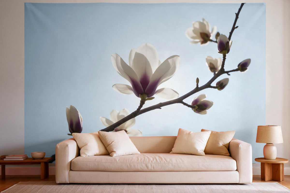 Tapiz de pared XXL Rama de magnolia ante un cielo claro como decoración en un salón luminoso sobre el sofá