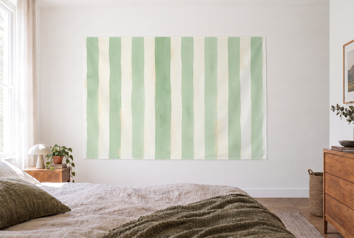 Wandtuch Markisenstreifen in Salbei und Creme im hellen Schlafzimmer gegenüber dem Bett, rechts eine Holzkommode – Grün