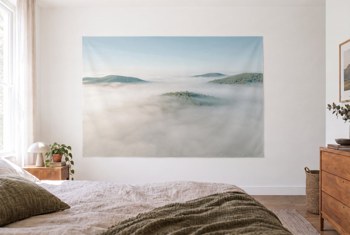 Tenture murale mer de brouillard dans la chambre claire face au lit, commode en bois à droite – blanc, bleu et vert