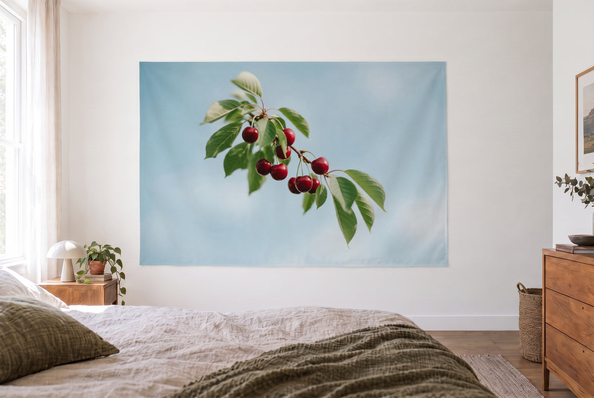 Wandtuch Reife Kirschen am Zweig im hellen Schlafzimmer gegenüber dem Bett, rechts eine Holzkommode – Rot und Himmelblau