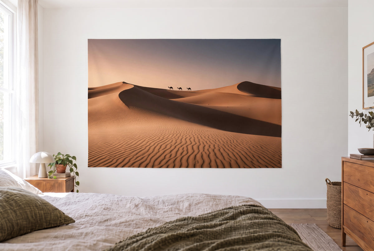 Tapiz desierto con dunas al atardecer en dormitorio claro frente a la cama, cómoda de madera a la derecha – dorado arena