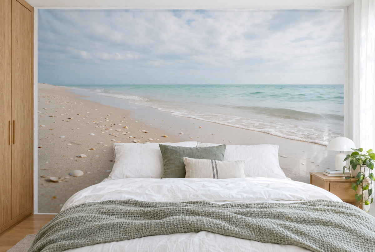 Bedruckter Stoff im XXL-Format: Sandstrand mit Muscheln und Türkiswasser unter Wolken, wandfüllend hinter dem Bett