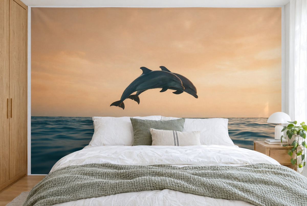 Bedruckter Stoff im XXL-Format: zwei Delfine mittig über dem Horizont, darunter blaues Meer, wandfüllend hinter dem Bett