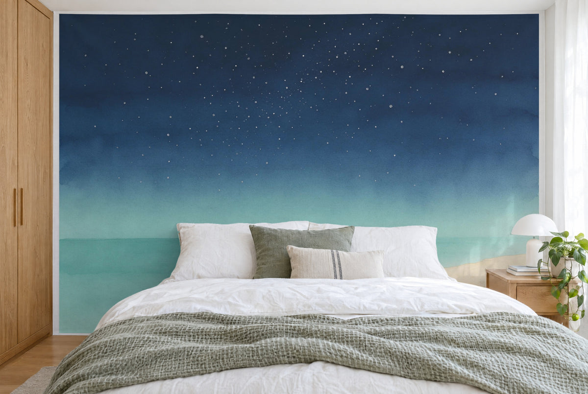 Bedruckter Stoff im XXL-Format: Sternenhimmel über Meer und Sandstrand rechts, wandfüllend hinter dem Bett