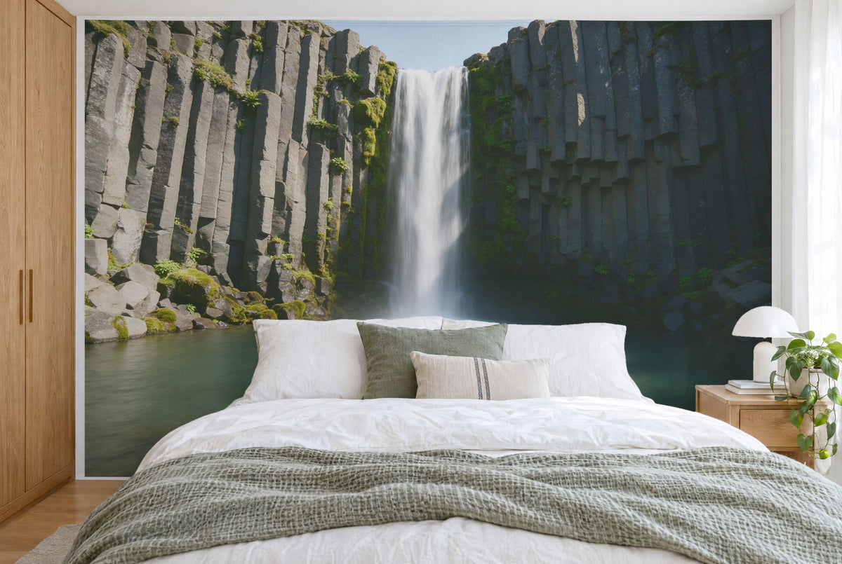 Bedruckter Stoff im XXL-Format: Wasserfall in der Mitte zwischen moosigen Basaltsäulen, wandfüllend hinter dem Bett