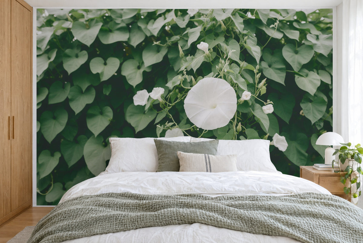 XXL printed fabric: large white moonflower blossom right of centre, heart-shaped leaves, full wall behind the bed