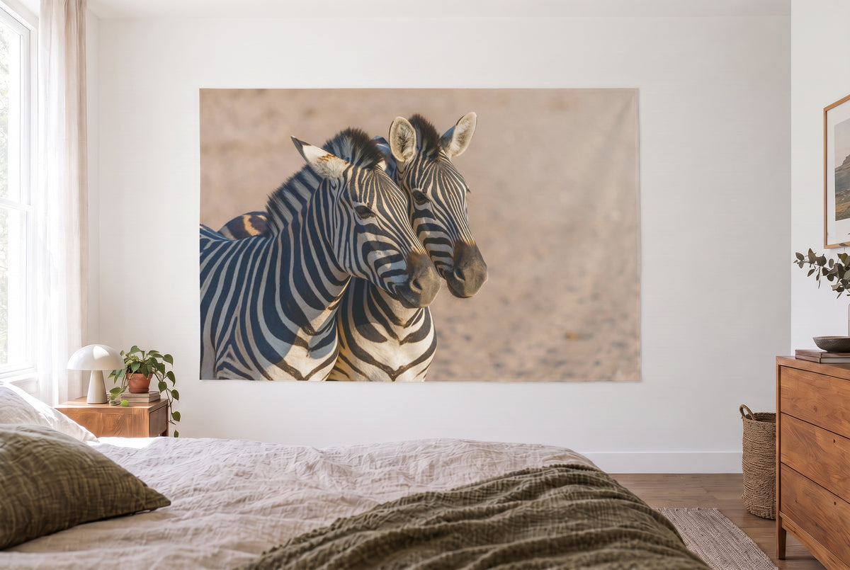 Wandtuch Zebras in Nahaufnahme im hellen Schlafzimmer gegenüber dem Bett, rechts eine Holzkommode – Weiss und Beige