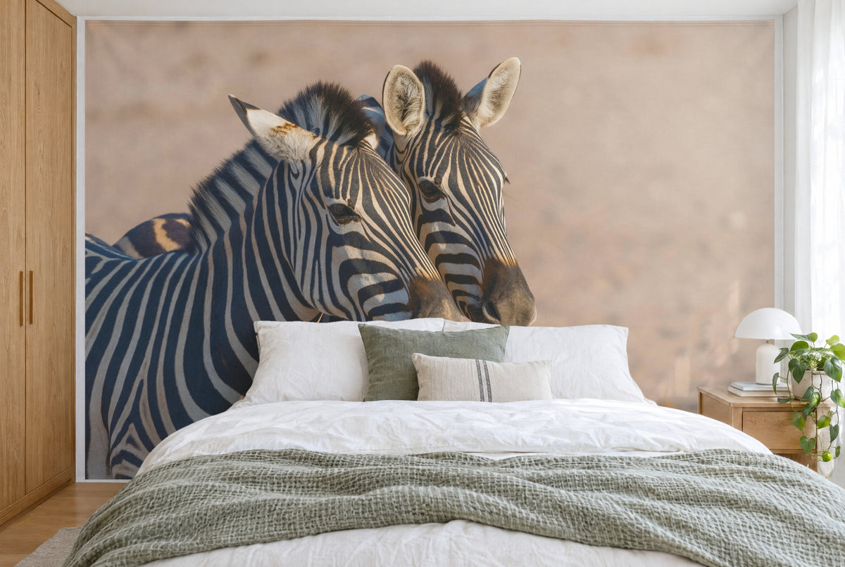 Bedruckter Stoff im XXL-Format: zwei Zebraköpfe links der Mitte, sandbeiger Hintergrund, wandfüllend hinter dem Bett