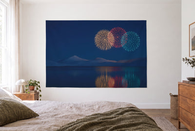 Wandtuch Feuerwerk über dem Bergsee im hellen Schlafzimmer gegenüber dem Bett, rechts eine Holzkommode – Nachtblau und Gold
