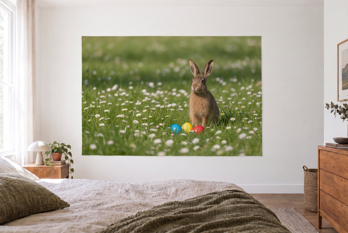 Wandtuch Osterhase auf der Gänseblümchenwiese im hellen Schlafzimmer gegenüber dem Bett, rechts eine Holzkommode – Grün