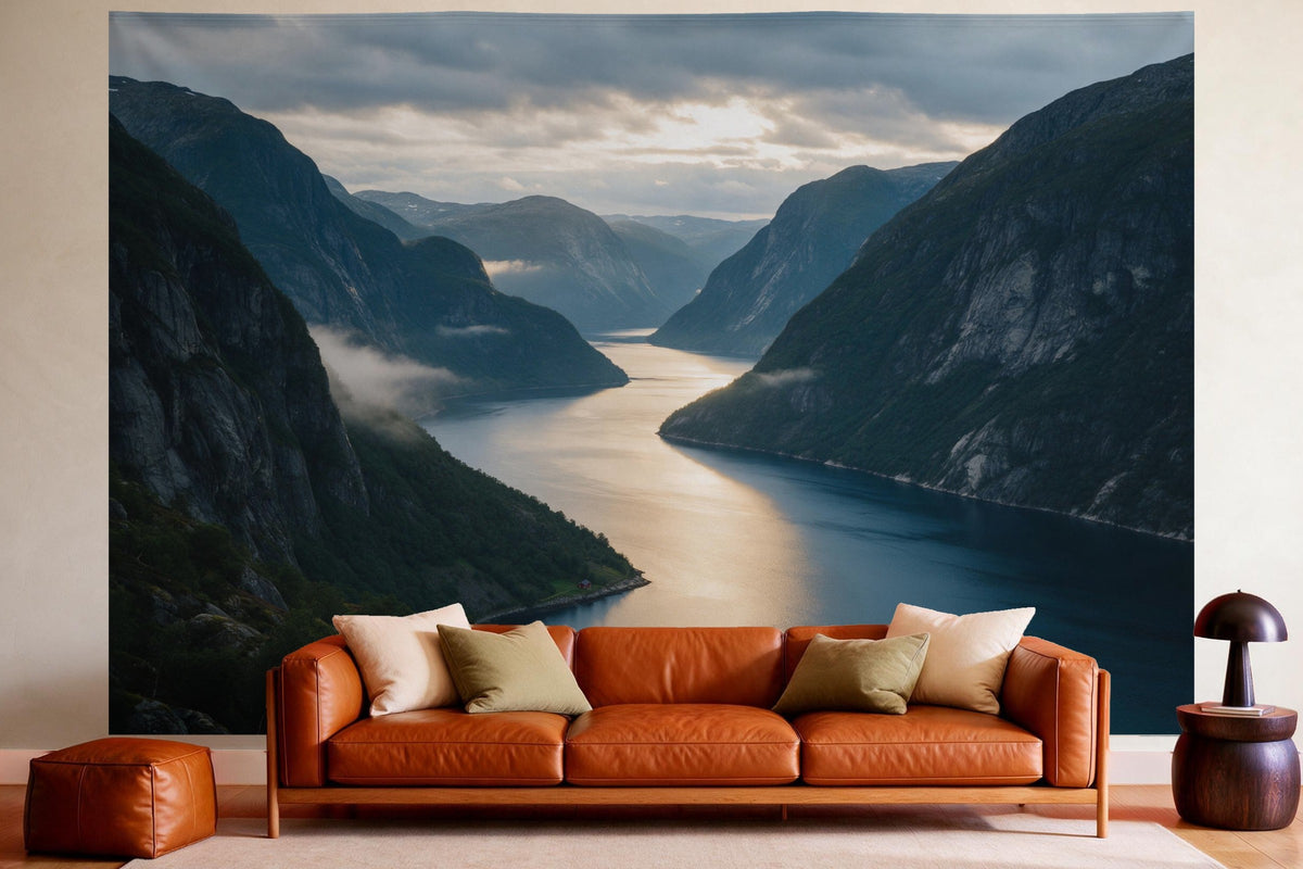 Tenture murale XXL Fjord dans la lumière du soir en déco murale dans un salon chaleureux au-dessus du canapé en cuir