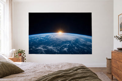 Wandtuch Erde aus dem All im hellen Schlafzimmer gegenüber dem Bett, rechts eine Holzkommode – Blau und Schwarz