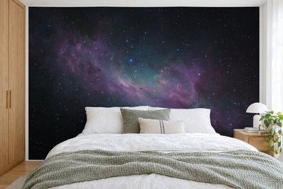Bedruckter Stoff im XXL-Format: violetter Sternennebel diagonal durch die Mitte, ringsum Sterne, wandfüllend hinter dem Bett
