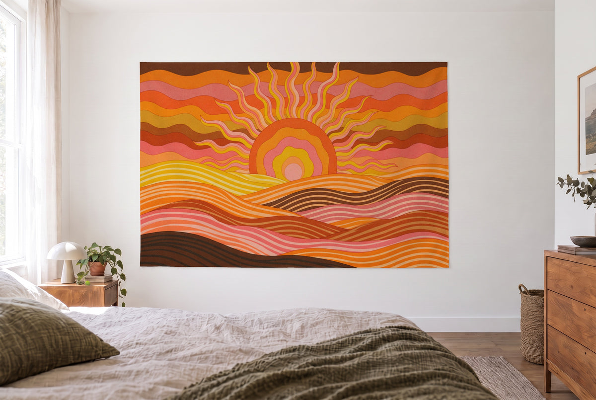 Wandtuch Psychedelic-Sonne über Wellenbergen im hellen Schlafzimmer gegenüber dem Bett, rechts eine Holzkommode – Orange Rosa