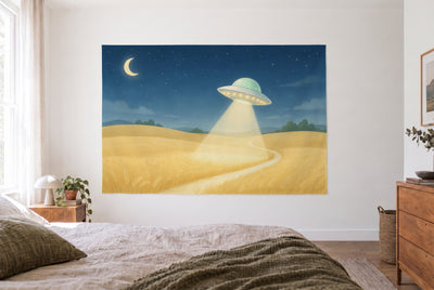 Wandtuch UFO über dem Weizenfeld im hellen Schlafzimmer gegenüber dem Bett, rechts eine Holzkommode – Blau, Gold und Grün