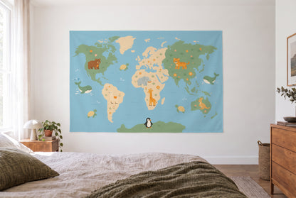 Wandtuch Weltkarte mit Tieren im hellen Schlafzimmer gegenüber dem Bett, rechts eine Holzkommode – Blau und Grün