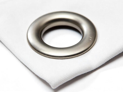 Nahaufnahme Stoffecke mit Metallöse: weisses Polyester mit silberner Öse zum Aufhängen – Variante mit Ösen