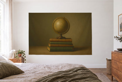 Tapiz globo antiguo sobre pila de libros en dormitorio claro frente a la cama, cómoda de madera a la derecha – ocre y marrón