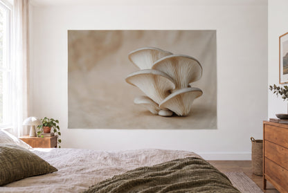 Tenture pleurotes en gros plan dans la chambre claire face au lit, commode en bois à droite – crème et beige