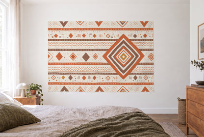 Berber pattern in earth tones tapestry in the bright bedroom opposite the bed, wooden dresser at right – orange and brown