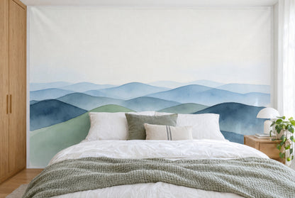 XXL printed fabric: sage green hill on the left in front of blue hill ranges, light sky, full wall behind the bed
