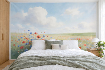 Bedruckter Stoff im XXL-Format: Mohn und Kornblumen links vorn, weite Wiese und Cumuluswolken, wandfüllend hinter dem Bett