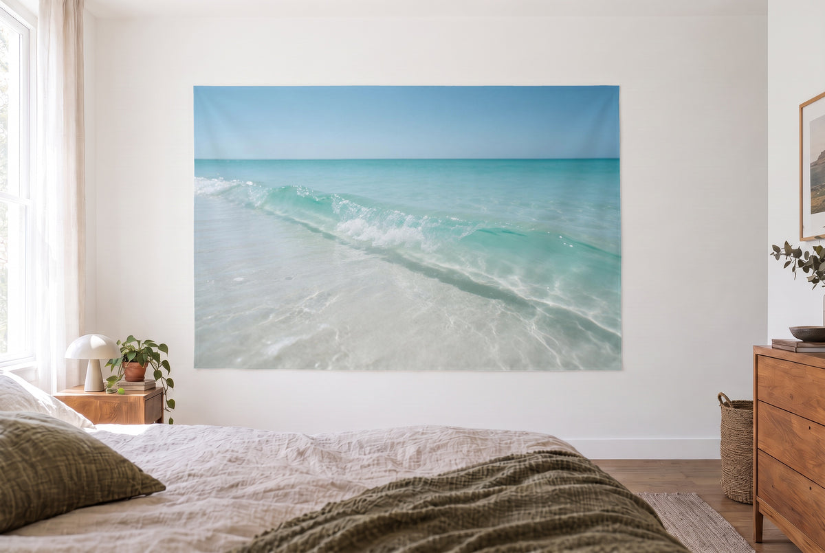Wandtuch Brandung am Sandstrand im hellen Schlafzimmer gegenüber dem Bett, rechts eine Holzkommode – Sandweiss