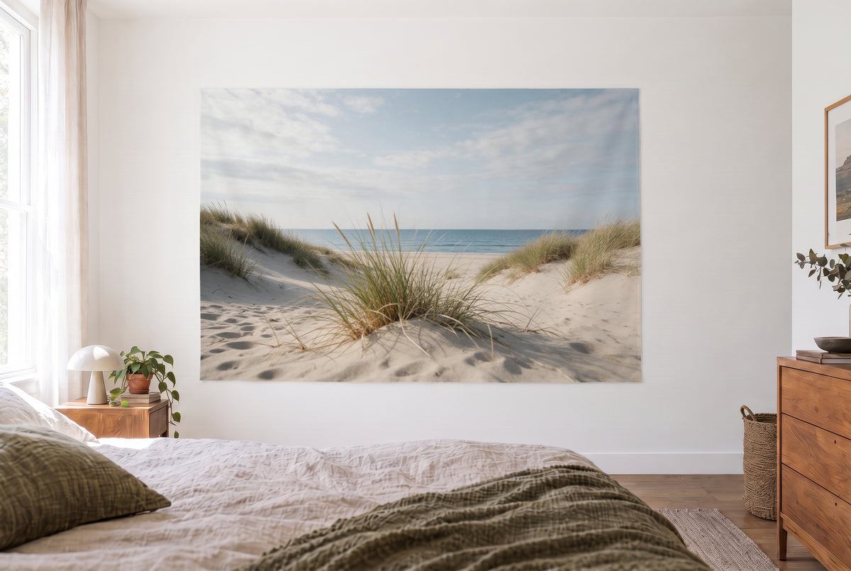 Tenture murale plage herbe des dunes dans la chambre claire face au lit, commode en bois à droite – beige et bleu