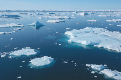 Eisberg und treibende Eisschollen auf tiefblauem Polarmeer, als Wandtuch, auf Stoff gedruckt – Blau und Weiss