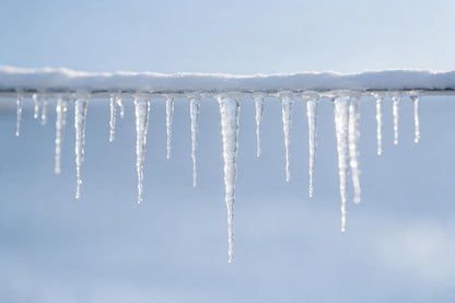 Clear icicles on a snow-covered roof edge before a pale blue winter sky, tapestry printed on fabric – ice blue and white