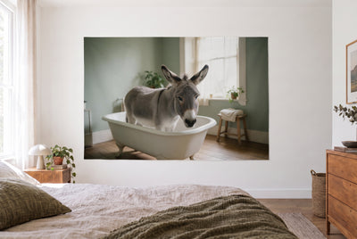 Wandtuch Esel in der Badewanne im hellen Schlafzimmer gegenüber dem Bett, rechts eine Holzkommode – Grau und Grün