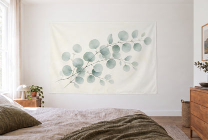Wandtuch Eukalyptuszweige als Aquarell im hellen Schlafzimmer gegenüber dem Bett, rechts eine Holzkommode – Grün und Beige