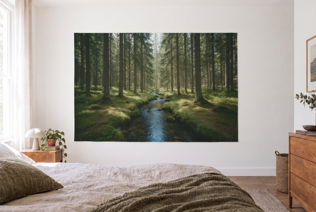 Wandtuch Fichtenwald mit Bachlauf im hellen Schlafzimmer gegenüber dem Bett, rechts eine Holzkommode – Grün und Blau