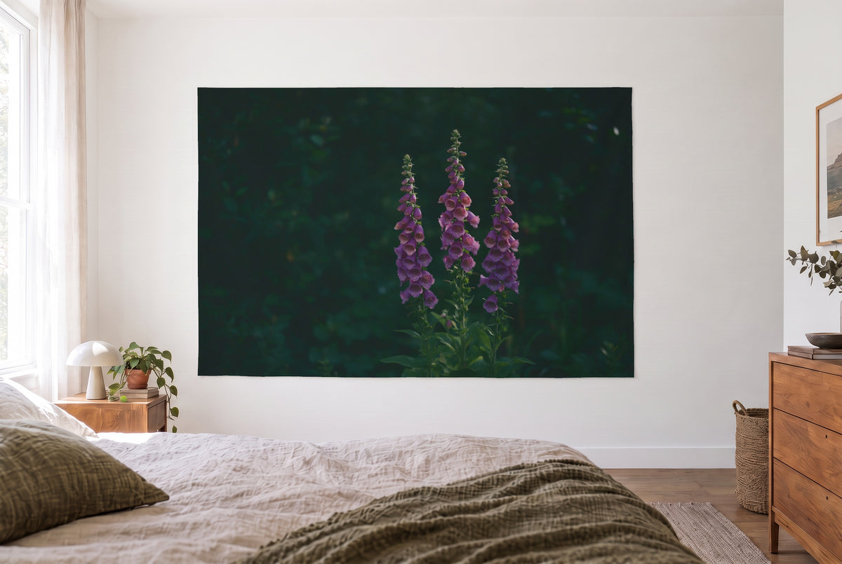 Foxglove on a Dark Background tapestry in the bright bedroom opposite the bed, wooden dresser on the right – violet and green